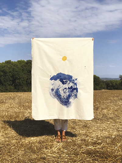 Personne dans un champ caché derrière une toile peinte de bleu et de jaune